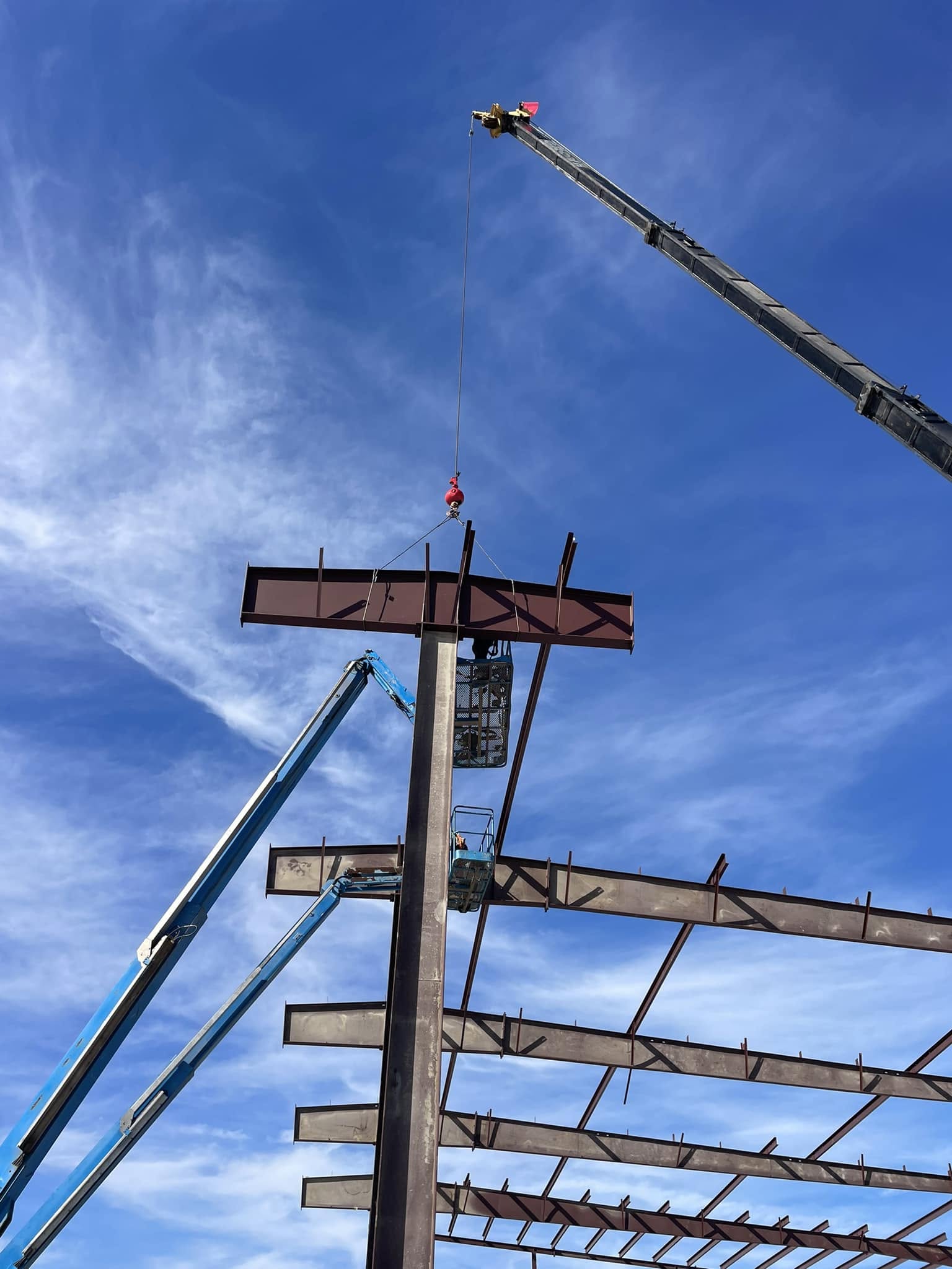 Crane lifting a structural steel beam during erection of the Fort Worth warehouse