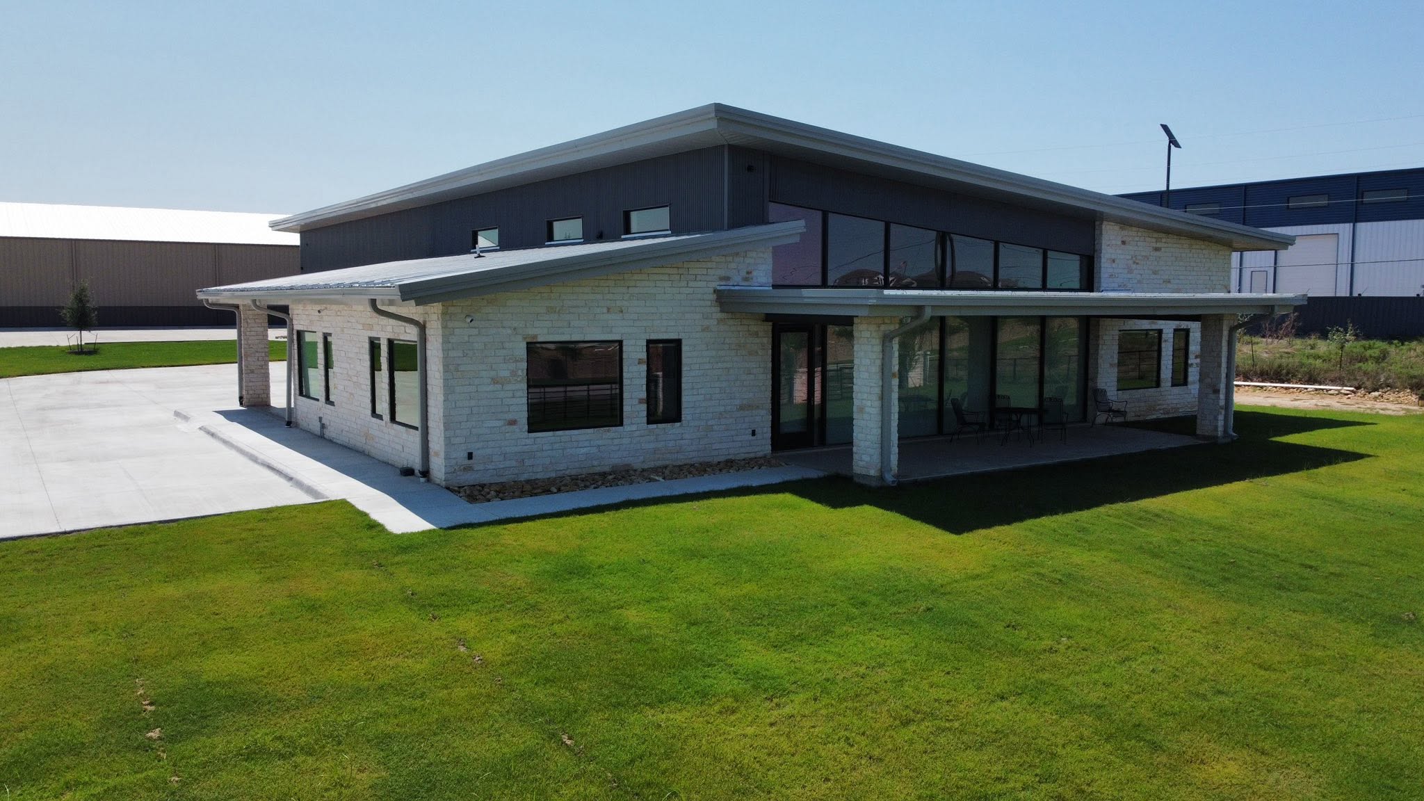 White-brick and dark-metal office building exterior with covered patio in Haslet, Texas