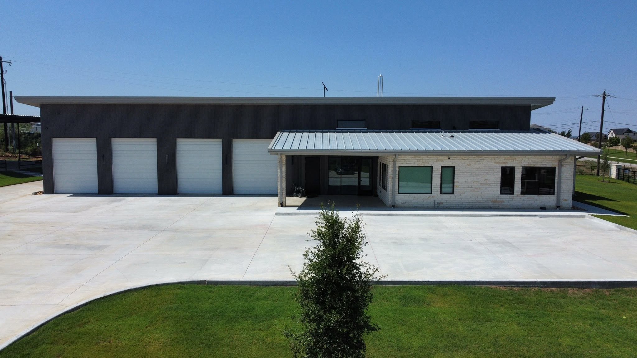 Front view of office building with four-bay metal shop in Haslet, Texas